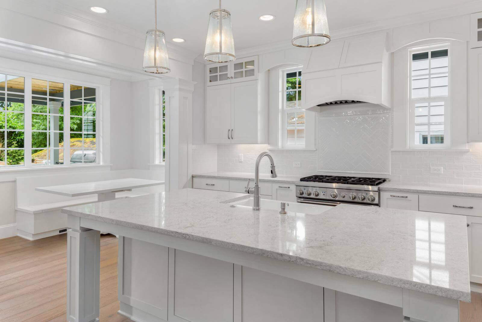 Beautiful White Kitchen in New Luxury Home with Hardwood Floors, Island, and Eating Nook