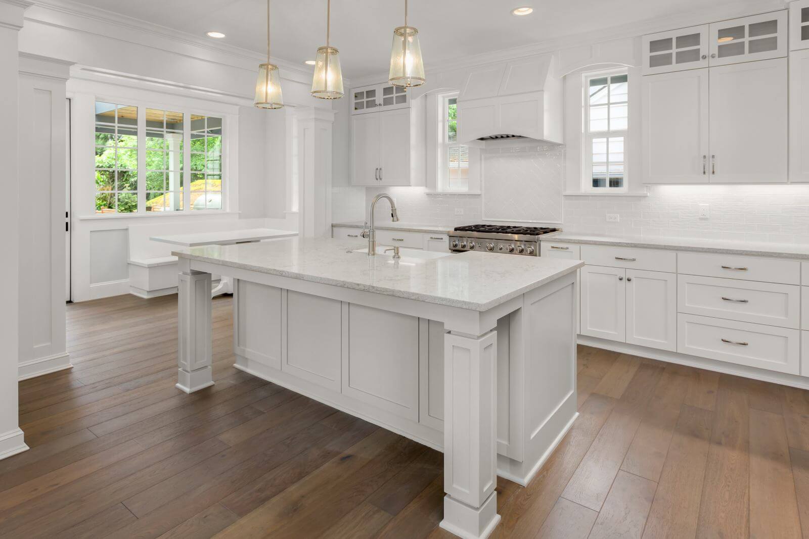 Beautiful White Kitchen in New Luxury Home with Hardwood Floors, Island, and Eating Nook