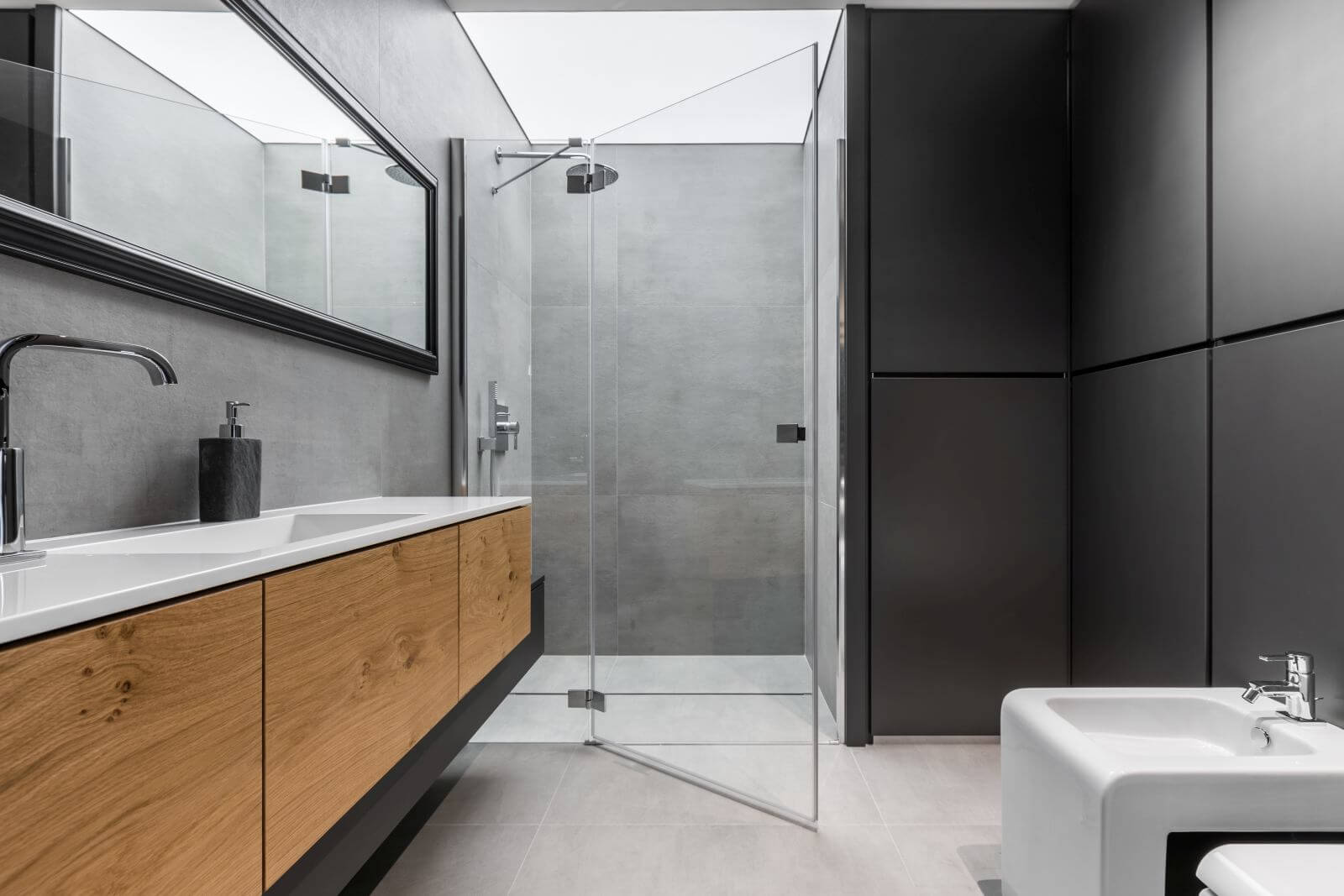 Modern, gray and black bathroom with shower, bidet, sink and wooden cabinet