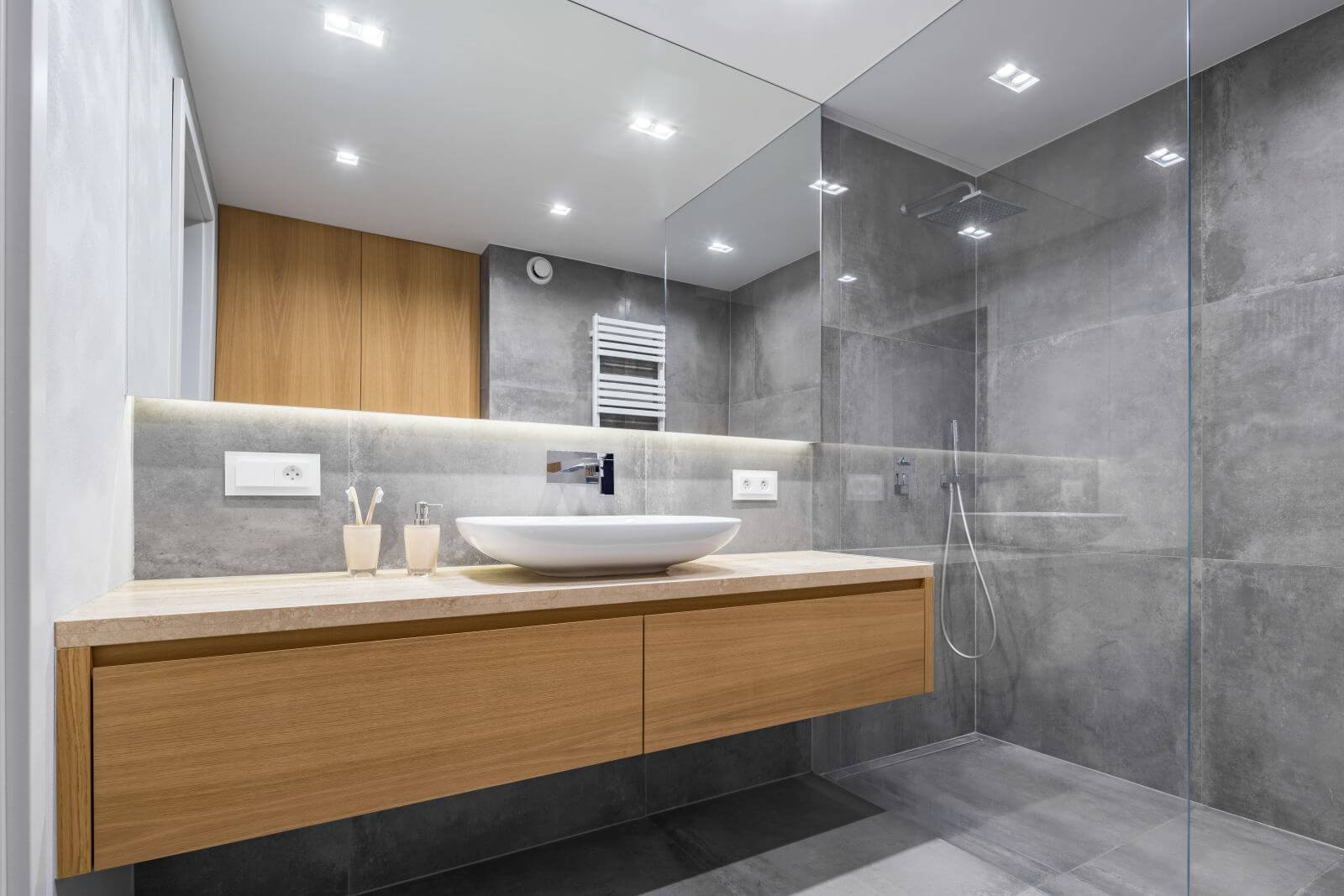 Modern bathroom with wooden countertop, shower, basin and big mirror