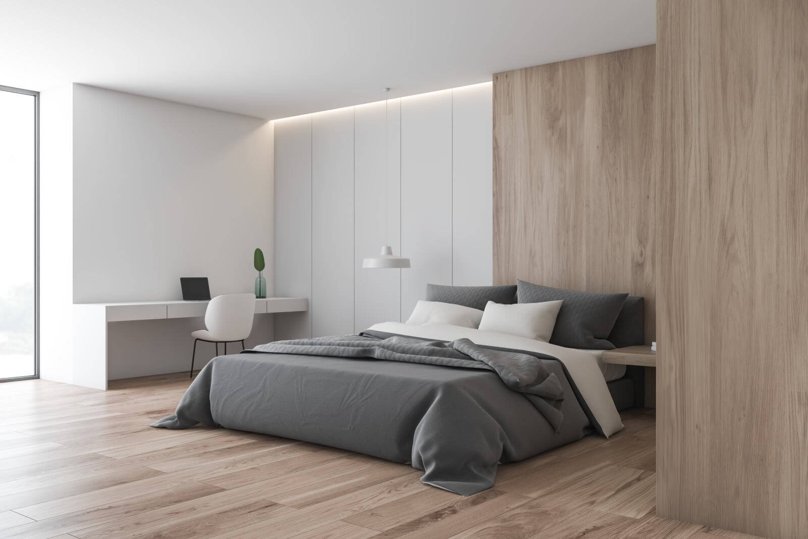 Corner of bedroom with white and wooden walls, wooden floor, master bed and white home office area with table and laptop. 3d rendering