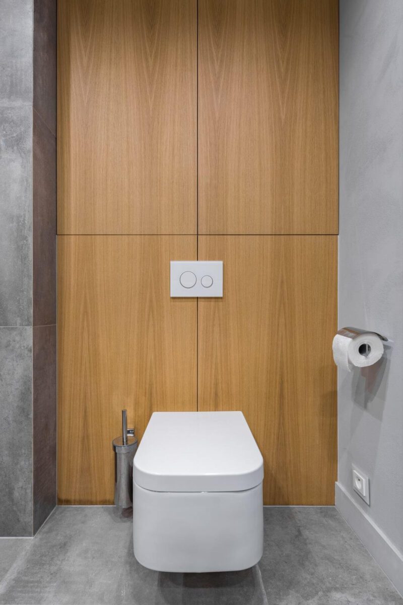 Gray bathroom with toilet and decorative wooden wall