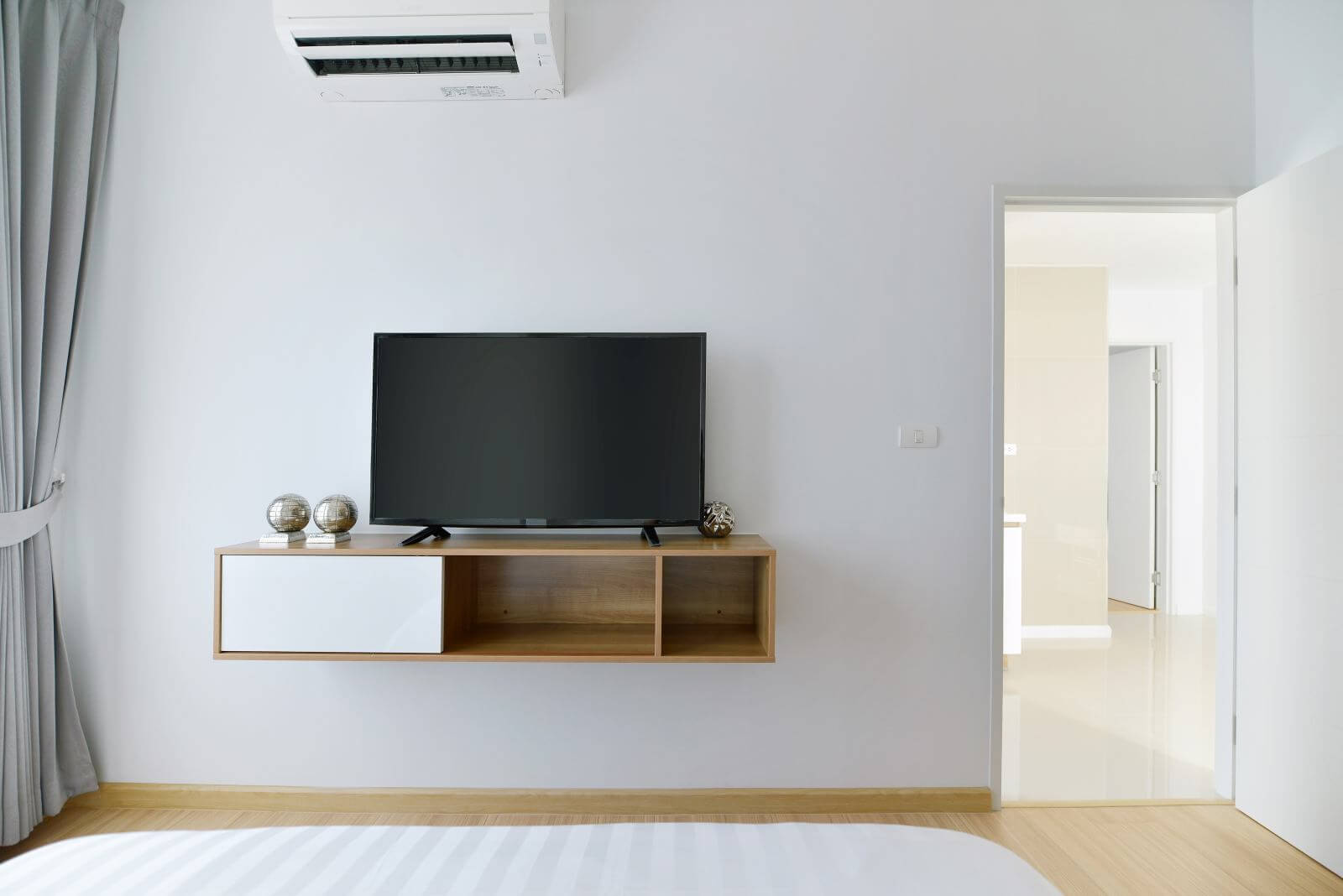 Modern Empty bedroom with led tv on white wall and wooden shelf