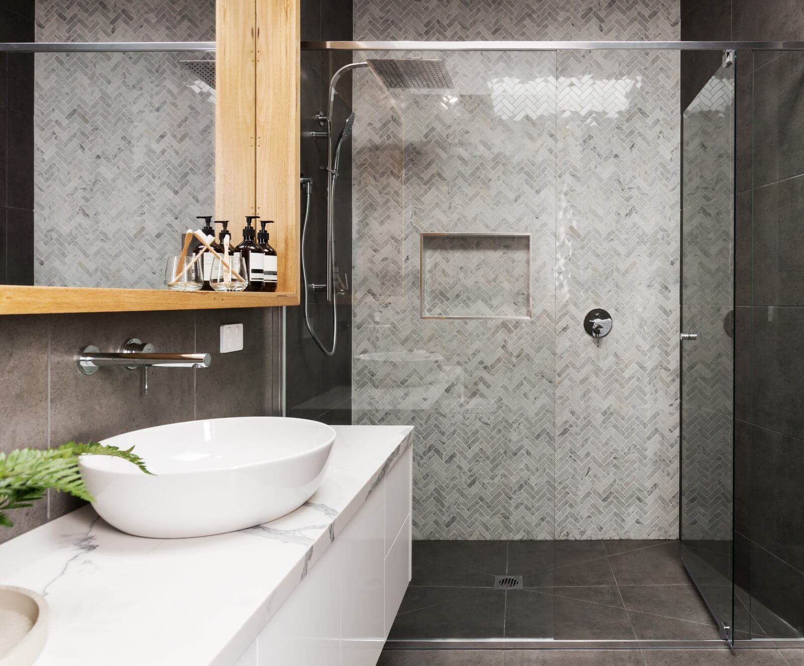 Marble mosaic herringbone tiled shower feature wall in a contemporary ensuite bathroom