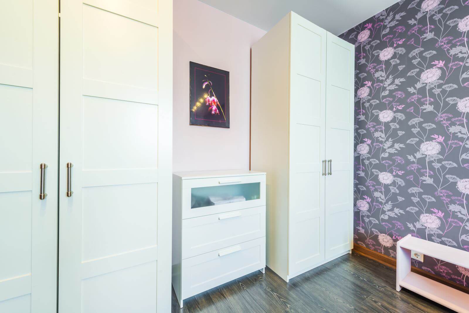 Interior bedrooms with wardrobes, chest of drawers, bedside table against the background of modern wallpaper