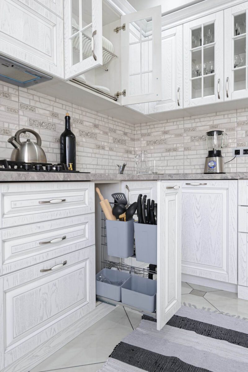 interior of modern white wooden kitchen in luxury home, some drawers are open