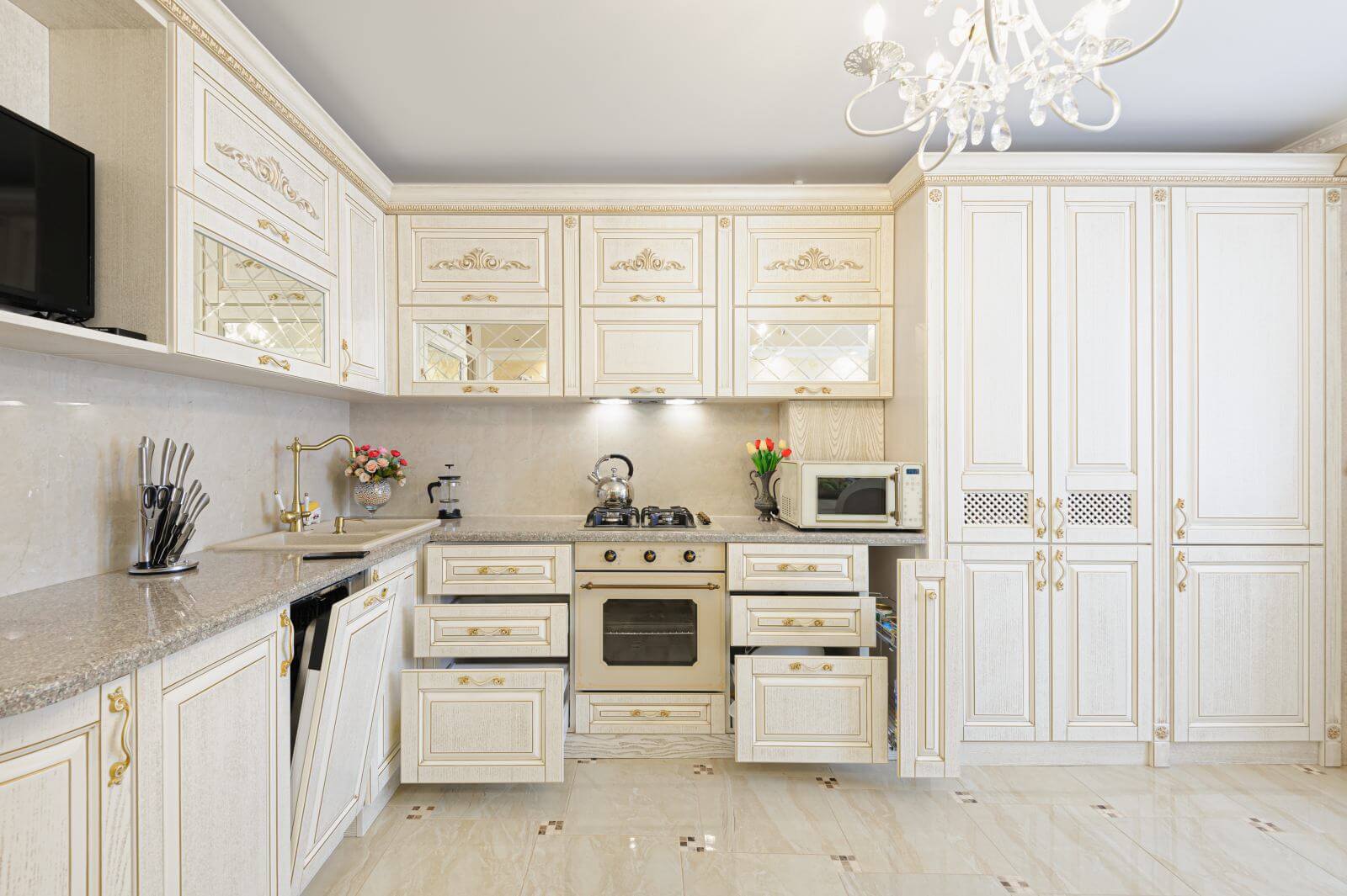 Luxury modern beige and cream colored kitchen in modern classic style. Some drawers are open