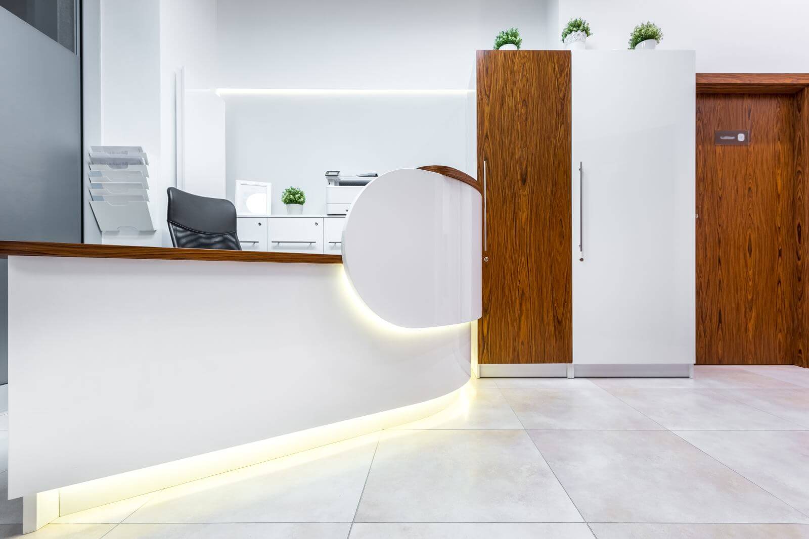 White interior with reception desk and wooden door