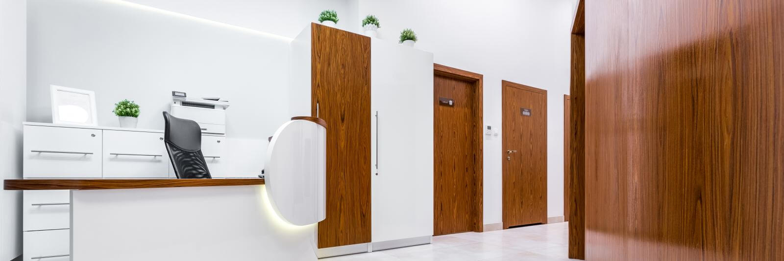 Panoramic view of modern reception in clinic with wooden doors and desk